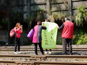 願い事を書いた天灯と一緒に記念写真を撮る観光客。