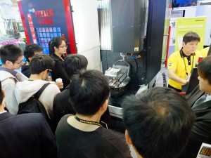 工作機械のデモンストレーションを見学する来場者