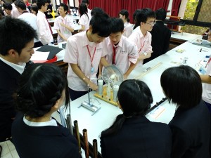 実験高校の学生の解説で清華大学の実験装置を見学する学生