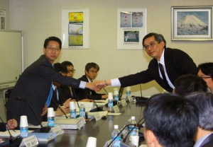 会合の成功を祈って握手する小松団長と周団長