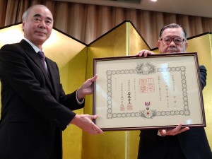 勲記を受け取る李雪峰氏（右）と樽井澄夫代表。