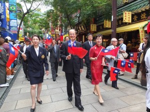駐日代表沈斯淳伉儷(右1、2)和橫濱華僑總會會長施梨鵬(左1)走在隊伍前頭,和民眾打招呼