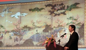 簽約記者會上,東京國立博物館調查研究課長田良島哲,在投影幕上介紹日本國寶《觀楓圖屏風》(照片提供:中央社)