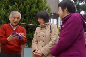 全日本崇正會聯合總會幹事長劉宏成,向日本友人解說桐花5月飄落時彷彿降雪一般的景緻