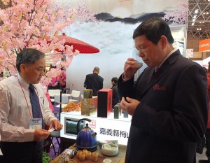 外貿協會副秘書長葉明水(右)在嘉義縣政府的攤位上試飲業者的阿里山紅茶