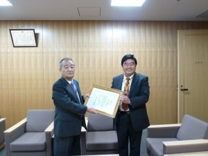 台北駐福岡経済文化弁事処の戎義俊処長(右)は、３月で退任する九州国立博物館の三輪嘉六館長(左)に対し感謝状を贈った