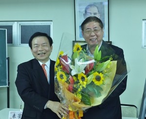 新任會長蘇成宗（左）獻花感謝前任會長李維祥對東京華僑總會的付出