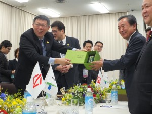 横浜市議員らに笑顔で記念品を送る柯市長