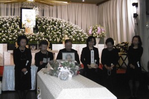 羅王阿嬤的女兒手捧靈位及遺照