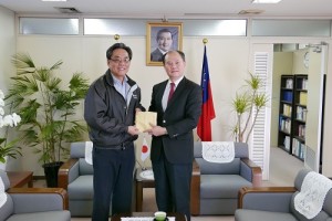 僑務委員鄭尊仁(左)熱心捐助200萬日幣,援助南台地震災區,由駐橫濱辦事處處長粘信士代表接受