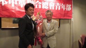 左：青年部馮明輝代表獻花給陳調和副代表