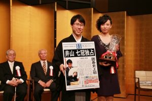 井山裕太十段（左）創下日本圍棋史上首次獨佔７冠頭銜，就位式上除了獎盃之外，產經新聞還特地送他新聞號外看板作為紀念（圖右為９連霸獲勝的謝依旻女流名人）