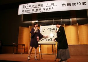 謝依旻（左）和井山裕太分別在台上解說棋盤