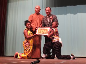 子供たちからアフリカの絵をプレゼントされた元参議院議員の大江康弘氏(右上)