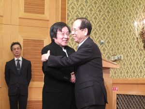 大橋会長と邱会長が笑顔で抱き合い、握手。