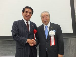 自民党東京都連の下村博文会長（左）も松本理事長に敬意を伝えた