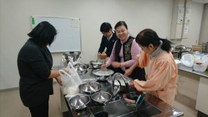 在會員張蓉容(左)指導下學習製作菜頭粿
