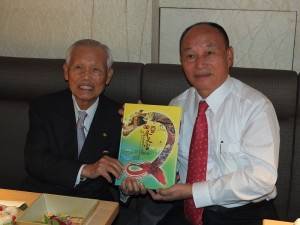 新港奉天宮何達煌董事長(右)，贈送媽租文化祭的介紹書籍給日本媽祖會創會名譽會長入江修正(左)