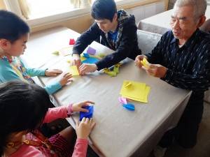 孫と一緒に折り鶴を折る男性、「昔はよく折っていたよ」と懐かしそうに話した