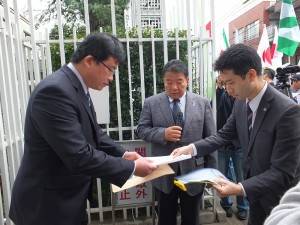 駐日代表處派員（左）出來分別收下主辦單位和在日台灣同鄉會等團體聯署的抗議聲明