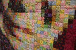 小さい四角に切ったバラバラの柄の布、およそ１万５千個を約２ヶ月間かけて繋ぎ合わせて作成