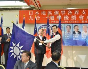 中國國民黨海外部主任夏大明（右）授黨旗給各地方分部，盼團結打贏選戰