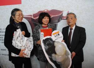 三輪館長（右）より図録を渡される福岡市の女性（中央）