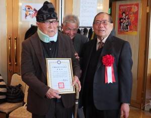 中央評議委員莊海樹（右）頒贈榮譽狀和金質徽章給入黨７０年的侯問源（左）