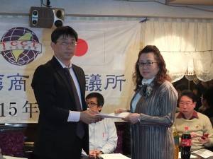 由律師王子裕林（左）轉交商會法人化的資料給會長錢妙玲