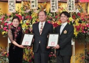 由駐橫濱辦事處處長粘信士（中）代表僑務委員會頒贈感謝狀給橫濱華僑總會，由會長施梨鵬（左）代表領獎，以及去年國慶活動執行委員長李明杰（右）