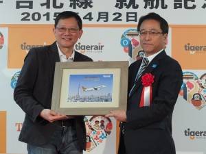 記念品の贈呈。關栩CEO（左）と成田国際空港執行役員エアライン事業部の荒川武部長（右）
