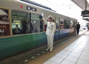 由池袋車站管區長土屋敏行在月台發出發車指令