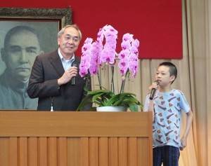 東京中華學校校長劉劍城現場直接請小學三年級的學生上台做即時翻譯