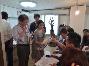 活動執行委員會的工作人員發送海報和傳單給店家發送