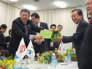 横浜市議員らに笑顔で記念品を送る柯市長