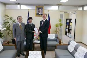 眾議員田中和德偕同川崎市議員松原成文將賑災款轉交給駐處處長粘信士(右)