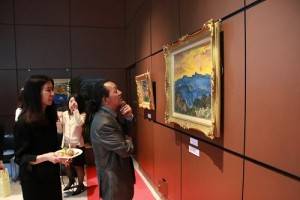 與會來賓在畫作《玉山日出》前駐足仔細欣賞