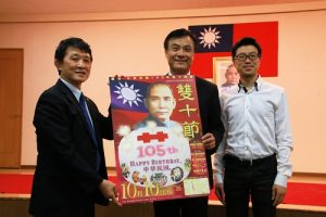 橫濱華僑總會會長羅鴻健（左）向立法院長蘇嘉全（右２）展示今年雙十國慶遊行的海報