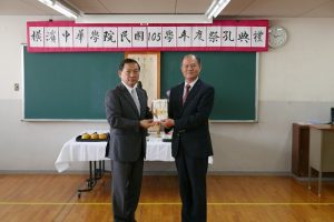 駐橫濱辦事處處長粘信士（右）代替駐日代表謝長廷和駐處頒贈教師節紀念品，由橫濱中華學院校長馮彥國代表收下