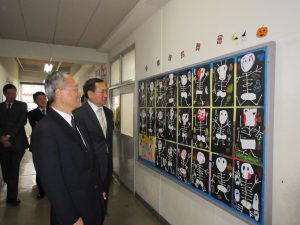 僑務委員長吳新興訪問橫濱中華學院，觀賞學生萬聖節作品（後為校長馮彥國）