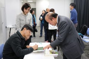 日本國際客家文化協會會長邱泱棟(右)請甘耀明簽名