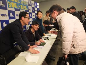 一人一人丁寧にサインする甘さん