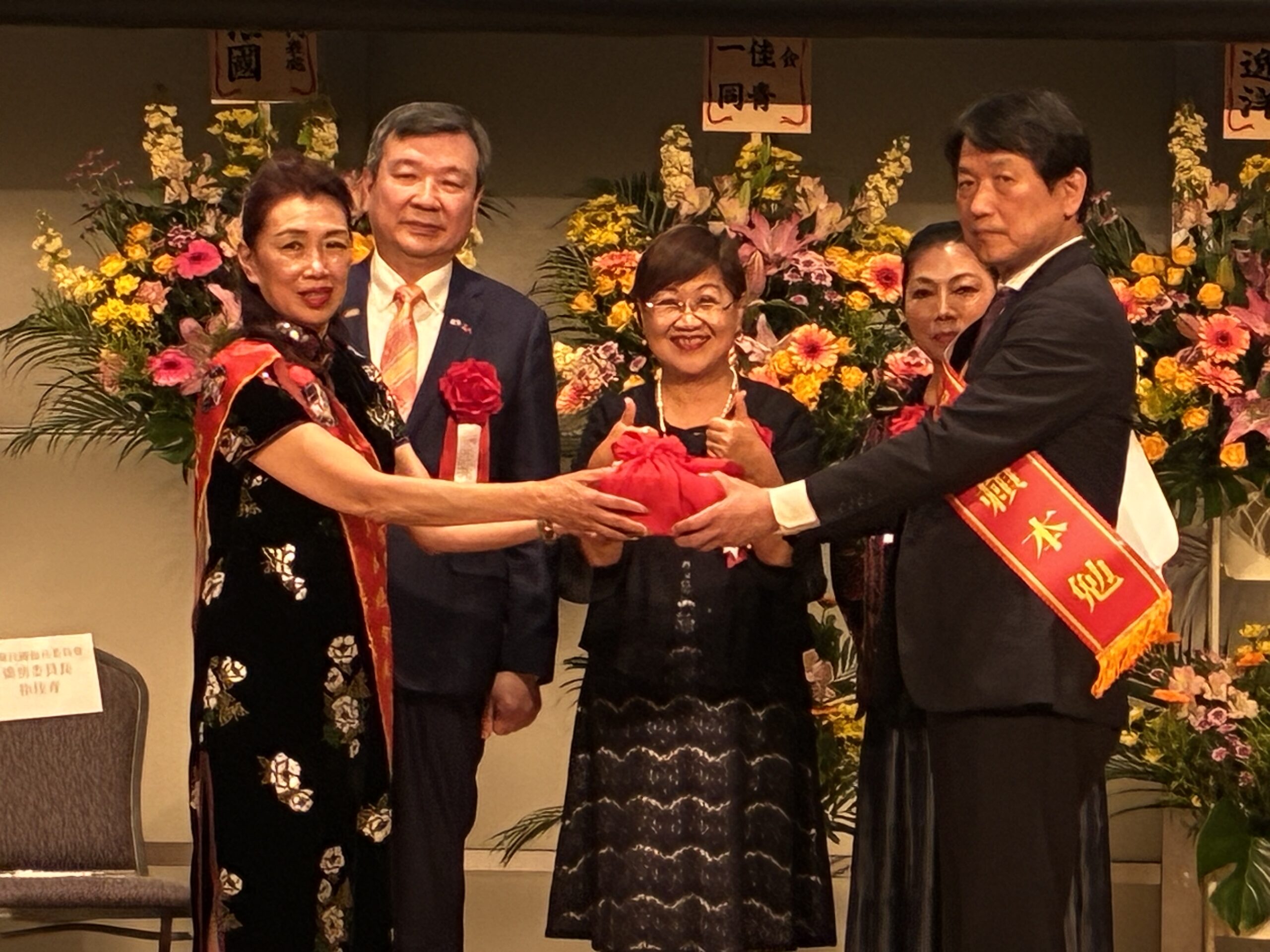第13屆洪益芬總會長(左1)、李逸洋大使(左2)、徐佳青委員長(中)、亞洲台商會總會長陳舒琴(右2)、第14屆賴本勉總會長(右1)